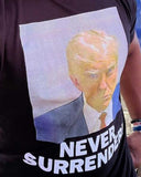 BLACK Our Trump Mugshot "Never Surrender" Short-Sleeve T Shirt is available in size M-XXXXL. We offer fast shipping and handle each order with care. #Trump #Mugshot #NeverSurrender #TShirt 