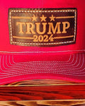 Trucker-Style Trump 2024 Leather Patch Hat with white mesh back.  The leather patch is custom made, hand-cut, and hand-stamped in the USA. Available in Red. 